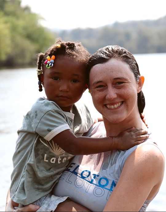 smiling child and adult in front of lake