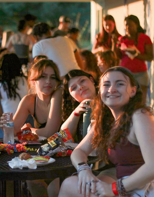 Group of smiling youth teenagers at outside table 