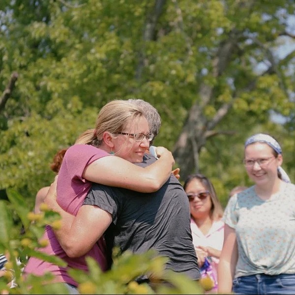 Group of adults hugging outside