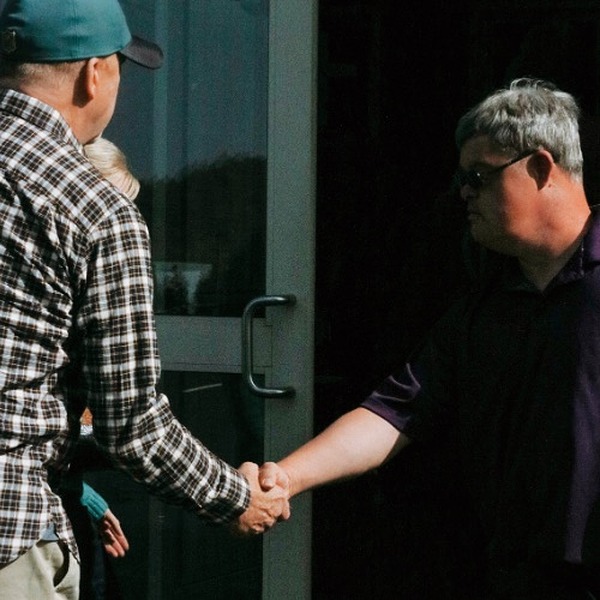 two people shaking hands outside of church