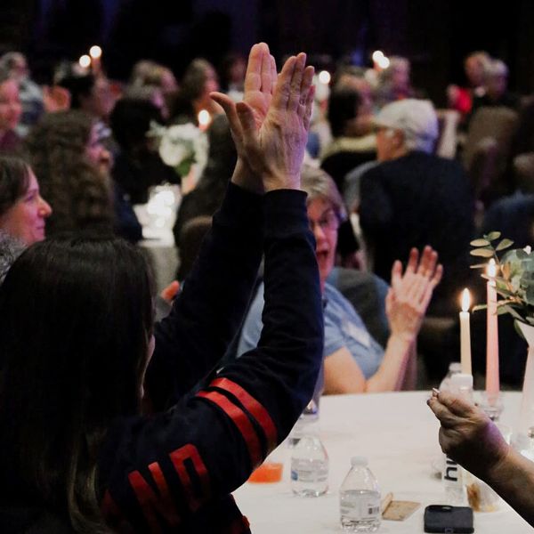 crowd cheering at table during event