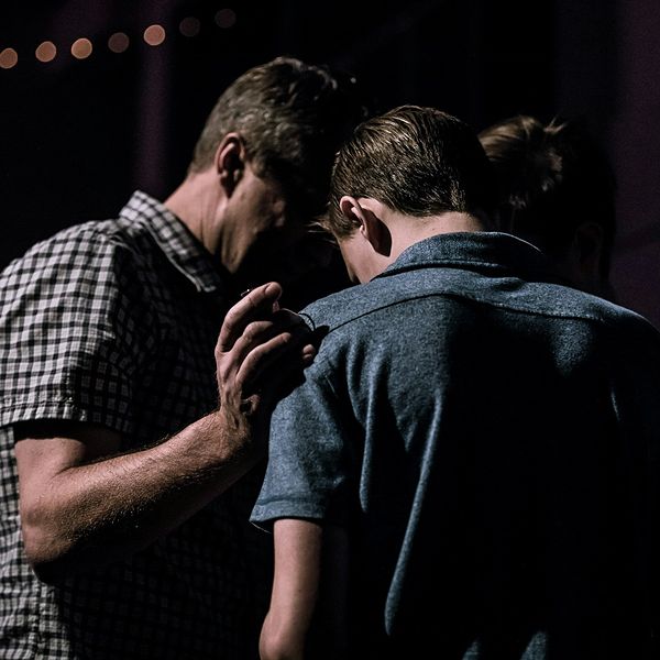 men praying in circle together