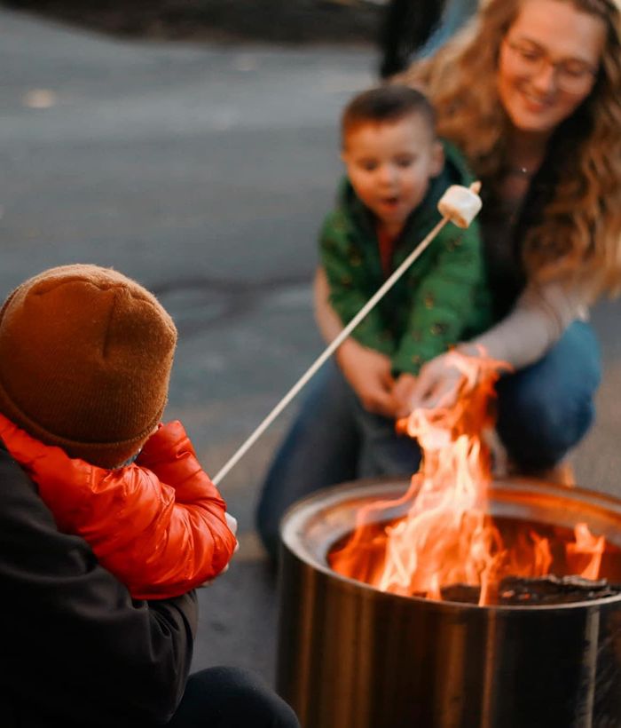family toasting marshmallows at bonfire