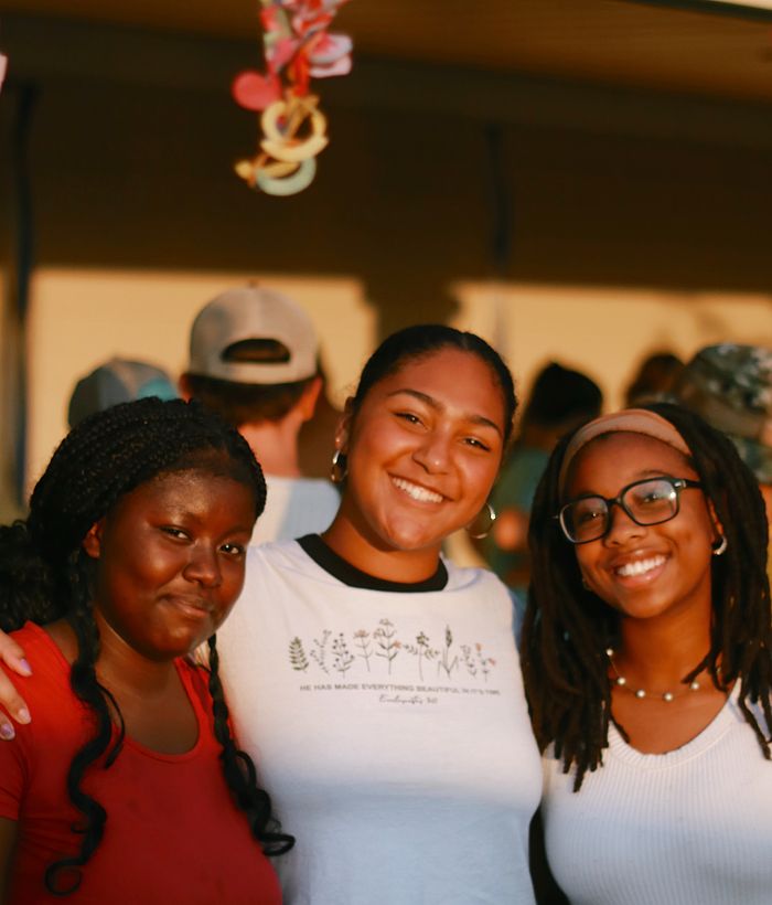 three girls smiling at sunset