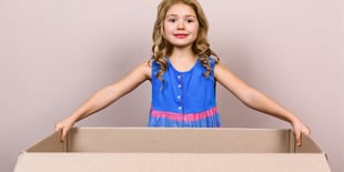 child playing with cardboard box
