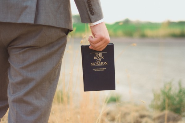 man holding the Book of Mormon