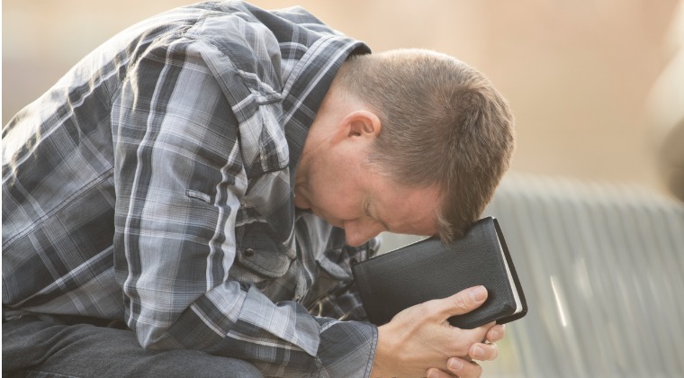 man on bench praying