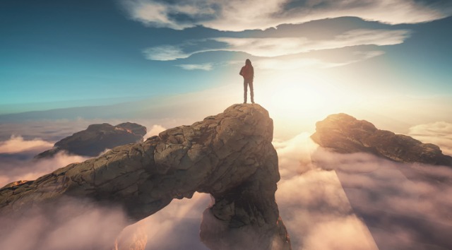 man on mountain above clouds 