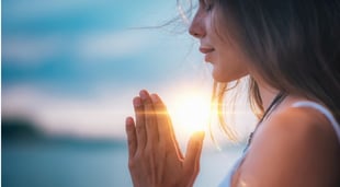 woman praying at sunrise