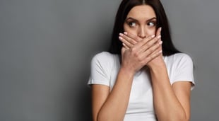 woman covering mouth after swearing