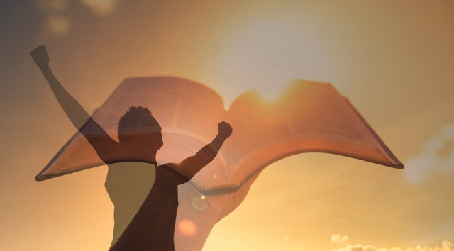 Strong man holding up bible feeling inspired